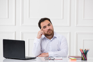 ADHD with computer young brunette office worker at work behind the desk trying to think