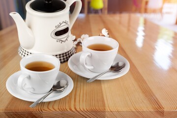 Tea concept with white tea set of cups and teapot with fresh tea on the desk