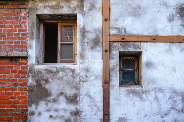 A old locking wooden window with the white cement wall.