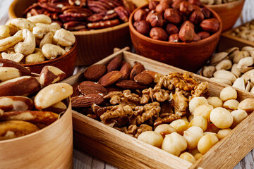 set of different nuts on a white wooden rustic background
