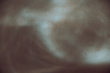 Sunbeams of various abstract shapes on a brown stone wall. Different lines and light spots on a plastered wall. Abstract multi-tasking background for different design tasks. Selective focus.