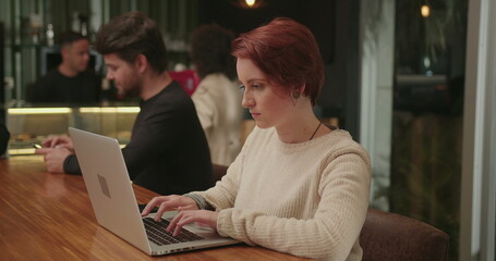 Young woman using laptop computer at cafe