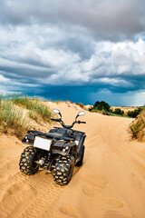 Quad bike on a sandy road. © badahos