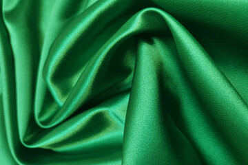 Green crumpled or wavy fabric texture background. Abstract linen cloth soft waves. Silk atlas or stretch jacquard. Smooth elegant luxury cloth texture. Concept for banner or advertisement.