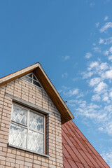 The attic outside is made of white brick and has an iron roof.