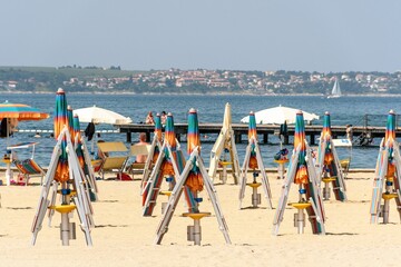 Deck chairs and parasols on a sandy beach in Portoroz, Slovenia.