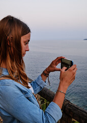 Foto scattata ad una ragazza mentre scatta una foto lungo il sentiero che collega Porto Azzurro con...