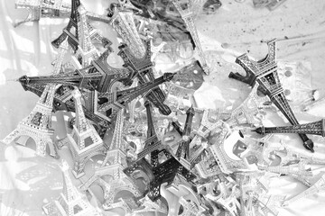 Grayscale closeup shot of a pile of Eiffel Tower souvenirs