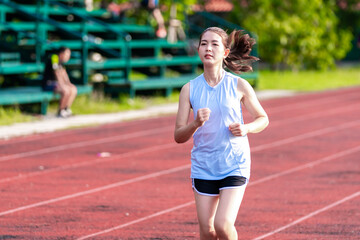 Asian women are jogging in the morning at the stadium to keep fit and healthy.