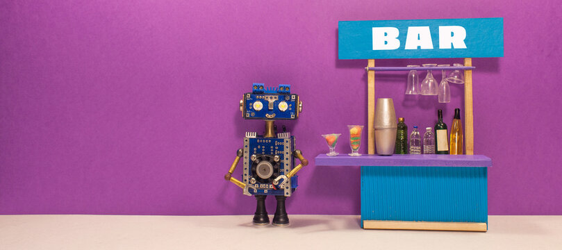 A robot bartender stands near a miniature bar counter with drinks: shaker and dishes. The concept of a toy business of a restaurant bar