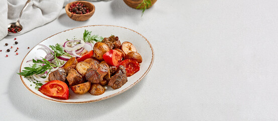 Traditional georgian dish odjahuri with meat and potatoes. Roasted pork fillet and potatoes with onion and tomatoes. Stew meat and potatoes. Eastern food with pork and spices