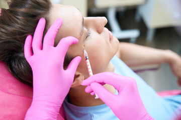 Man preventing wrinkles with fillers in beauty clinic