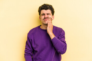 Young caucasian man isolated on yellow background having a strong teeth pain, molar ache.