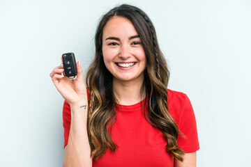 Young caucasian woman holding car keys isolated on blue background happy, smiling and cheerful.