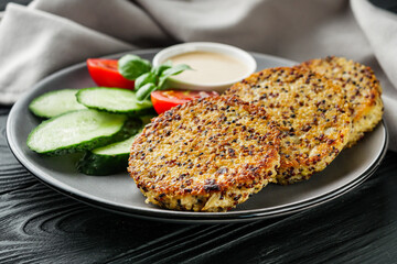 quinoa cutlet with vegetables on a black wooden rustic background
