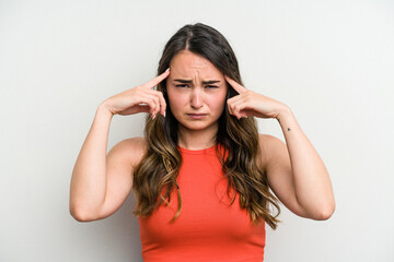 Young caucasian woman isolated on white background focused on a task, keeping forefingers pointing head.