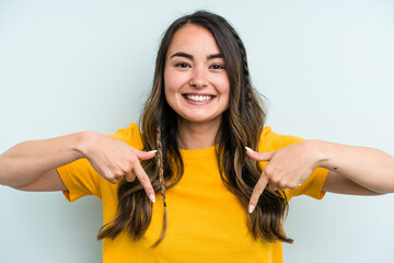 Young caucasian woman isolated on blue background points down with fingers, positive feeling.