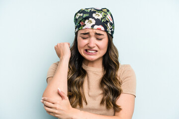 Young caucasian woman isolated on blue background massaging elbow, suffering after a bad movement.