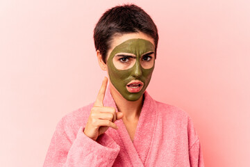Young caucasian woman wearing a face mask isolated on pink background having an idea, inspiration concept.