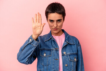 Young caucasian woman isolated on blue background standing with outstretched hand showing stop sign, preventing you.