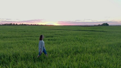 4K. Bird's-eye view. A happy woman walks merrily across the field.