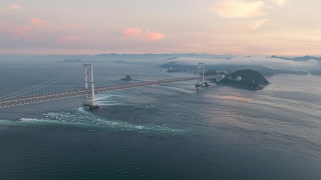 Aerial timelapse: Strong tidal current under Naruto Bridge at sunset