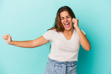 Young caucasian woman isolated on blue background  dancing and having fun.