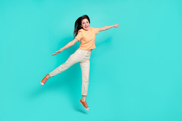 Fototapeta na wymiar Full size photo of ecstatic gorgeous girl jumping raise arms flying isolated on turquoise color background