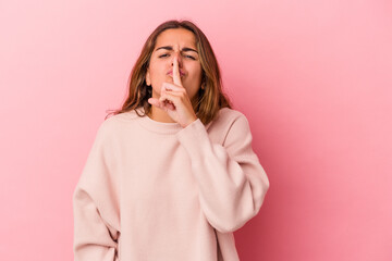 Young caucasian woman isolated on pink background  keeping a secret or asking for silence.