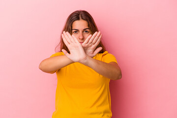 Young caucasian woman isolated on pink background  doing a denial gesture