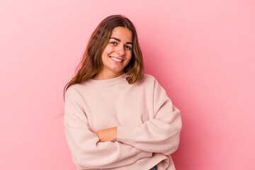 Young caucasian woman isolated on pink background  who feels confident, crossing arms with determination.