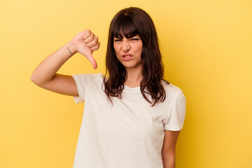 Young caucasian woman isolated on yellow background showing thumb down and expressing dislike.