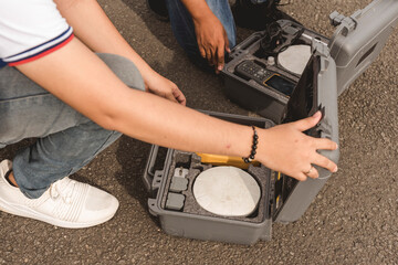Geodetic Engineers setting up real-time kinematic or RTK surveying equipment used in the field. A...