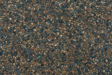 Texture of small multi-colored natural stone - river pebbles of gray and beige colors. sidewalk background. decorative coating for construction - wall and floor finishes in interiors