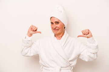 Middle age caucasian woman wearing a bathrobe isolated on white background feels proud and self confident, example to follow.