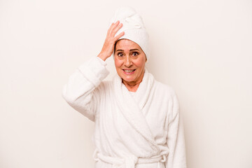 Middle age caucasian woman wearing a bathrobe isolated on white background being shocked, she has remembered important meeting. - obrazy, fototapety, plakaty