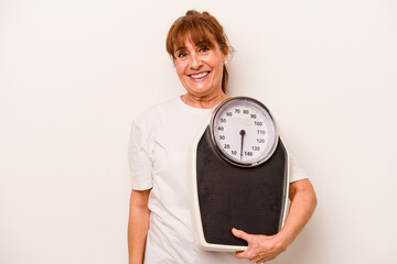 Middle age caucasian woman holding a scale isolated on white background happy, smiling and cheerful.
