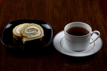 Cup of Tea with Slices of Cake on an Old Polished Table Top
