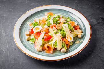 fresh salad with shrimp and parmesan on a black background