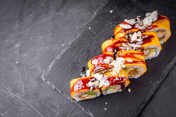delicious sushi rolls on a black stone background