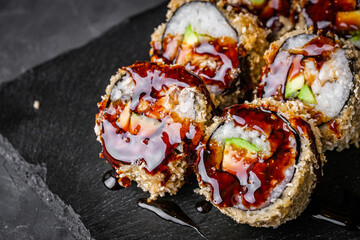 delicious sushi rolls on a black stone background