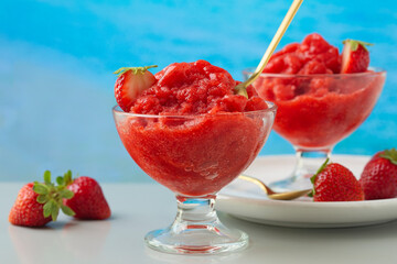 Strawberry granita Siciliana, a semi-frozen italian dessert on a sea background.