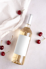 Bottle of white wine mockup with blank label and cherry berries