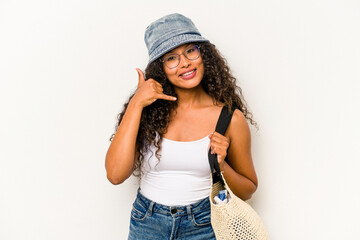 Young hispanic woman wearing a beach bag isolated on white background showing a mobile phone call...