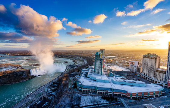 Aerial view of Niagara Falls City downtown horizon and Horseshoe Falls in a winter sunny day sunset time.