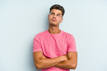 Fototapeta premium Young caucasian man isolated on blue background tired of a repetitive task.