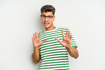 Young caucasian man isolated on white background rejecting someone showing a gesture of disgust.