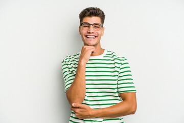 Obraz premium Young caucasian man isolated on white background smiling happy and confident, touching chin with hand.