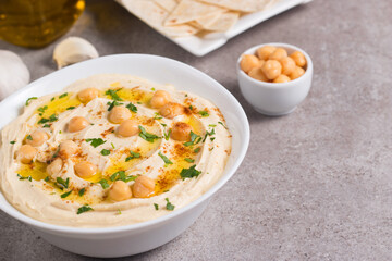 Hummus in a plate with chickpeas, smoked paprika, olive oil and pita. Vegetarian food.