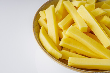 peeled potatoes sliced for french fries on a white background